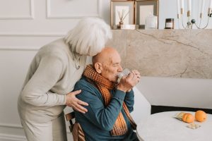 Loving elderly Aussie couple, AI in aged care concept. Cozy home moment.