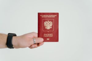Hand holding Russian passport, symbolizing the journey to Australian citizenship and its privileges.