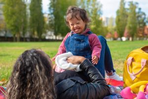 Smiling WA mother & child with Down syndrome picnic, supporting children with higher needs.