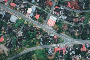 Sunshine Coast housing development high-angle shot, vibrant rooftops, green Malaysia.