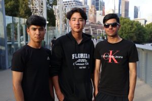 Young adults in Australia, diverse migrant group, urban skyline.