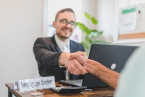 Mortgage broker handshake, finance deal with former banker wife. Australian finance news.