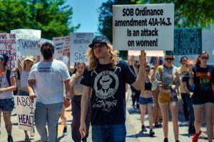 A diverse group of activists participating in a peaceful protest supporting women's rights with signs and placards.