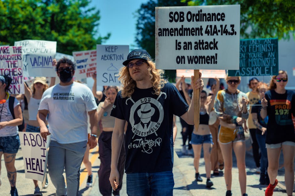 A diverse group of activists participating in a peaceful protest supporting women's rights with signs and placards.