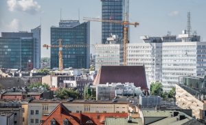 Urban skyline of Poznań with cranes and modern architecture in view.