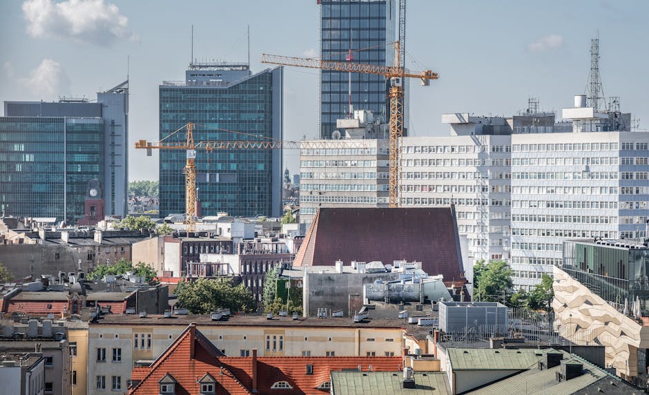 Urban skyline of Poznań with cranes and modern architecture in view.