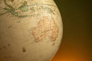 A close-up of a vintage map globe showcasing Australia and Indonesia against a warm background.