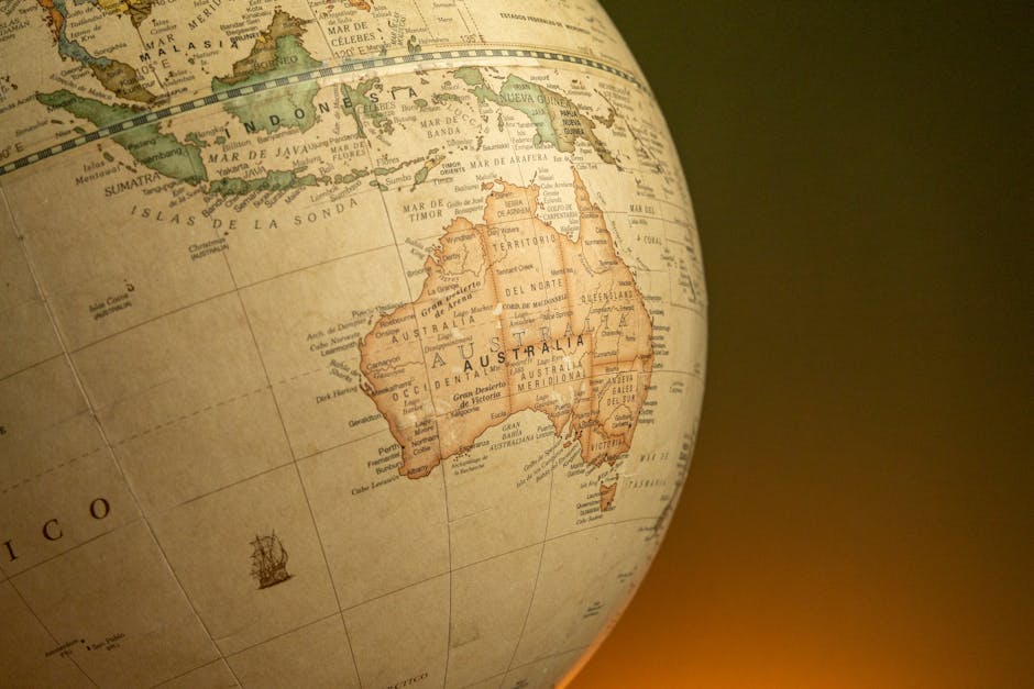 A close-up of a vintage map globe showcasing Australia and Indonesia against a warm background.