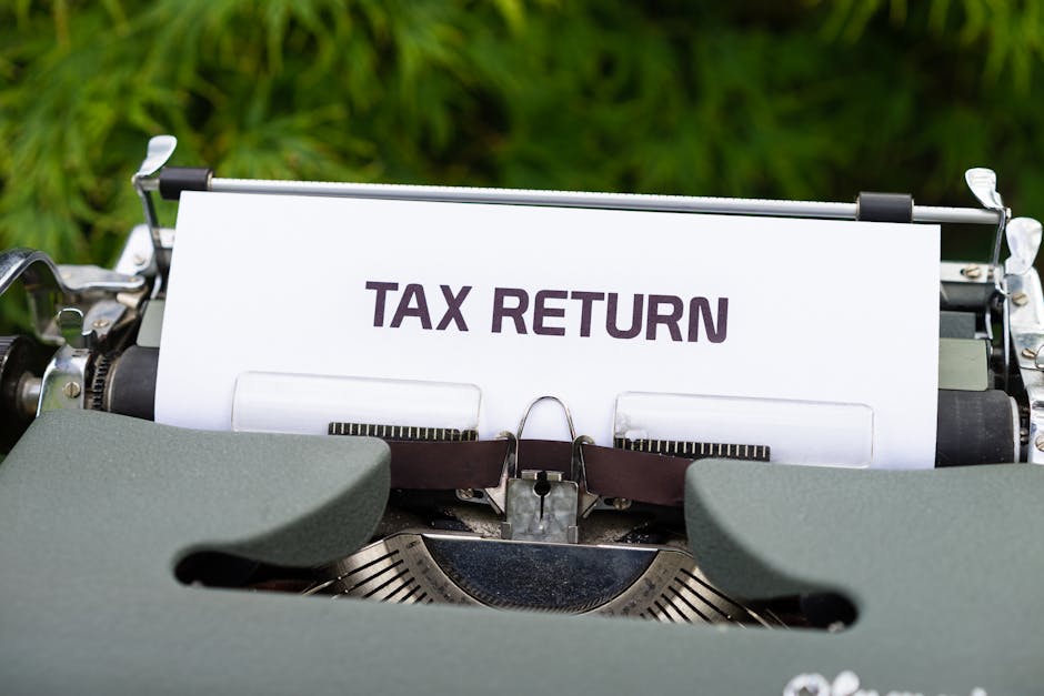 Close-up of a vintage typewriter typing 'Tax Return' on paper outdoors.