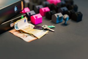 Australian property & insurance: Miniature houses, euro bills & key for solar/appliance upgrades.