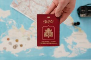 Hand with Russian passport over Australia map, visa travel prep, anti-corruption governance