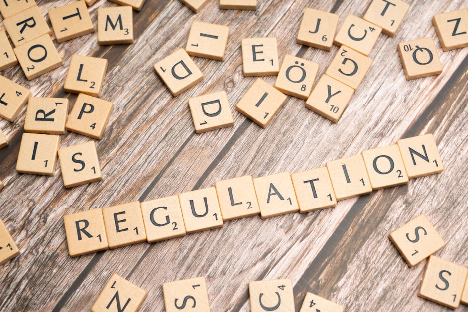 Wooden letter tiles spelling 'Regulation' on wood, representing business regulations Australia risks.