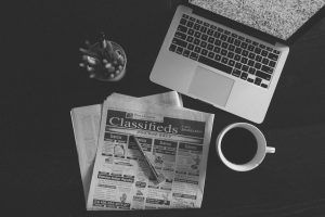 Laptop, newspaper, coffee on desk: classified information Australia context.
