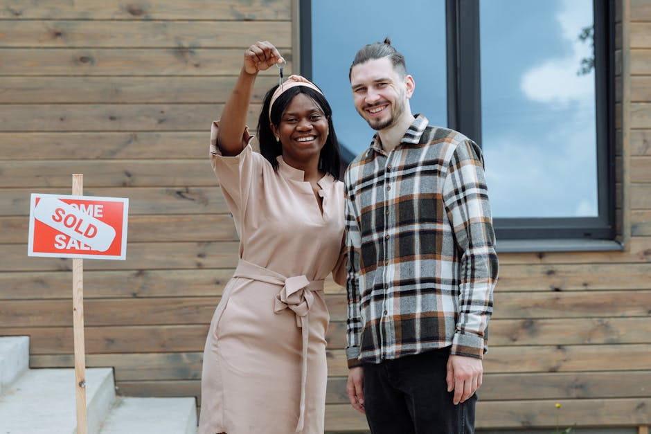 Young Aussie couple celebrates buying first home with keys, sold sign.